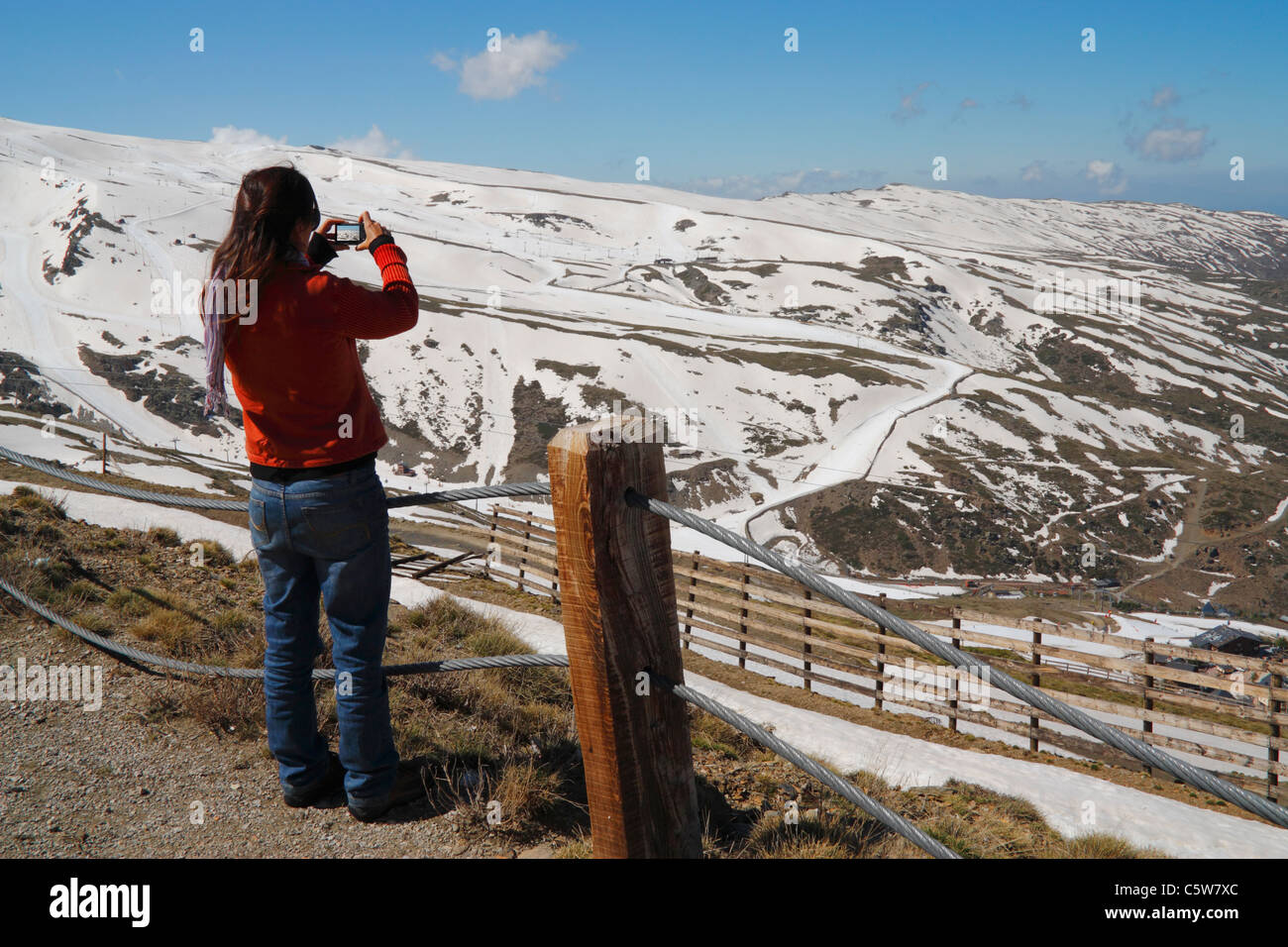 Donna di fotografare le piste da sci della Sierra Nevada National Park vicino a Granada, Andalusia, Spagna Foto Stock