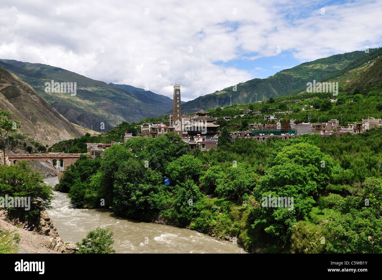 Un villaggio tibetano dalla banca di fiume. Sichuan, in Cina. Foto Stock