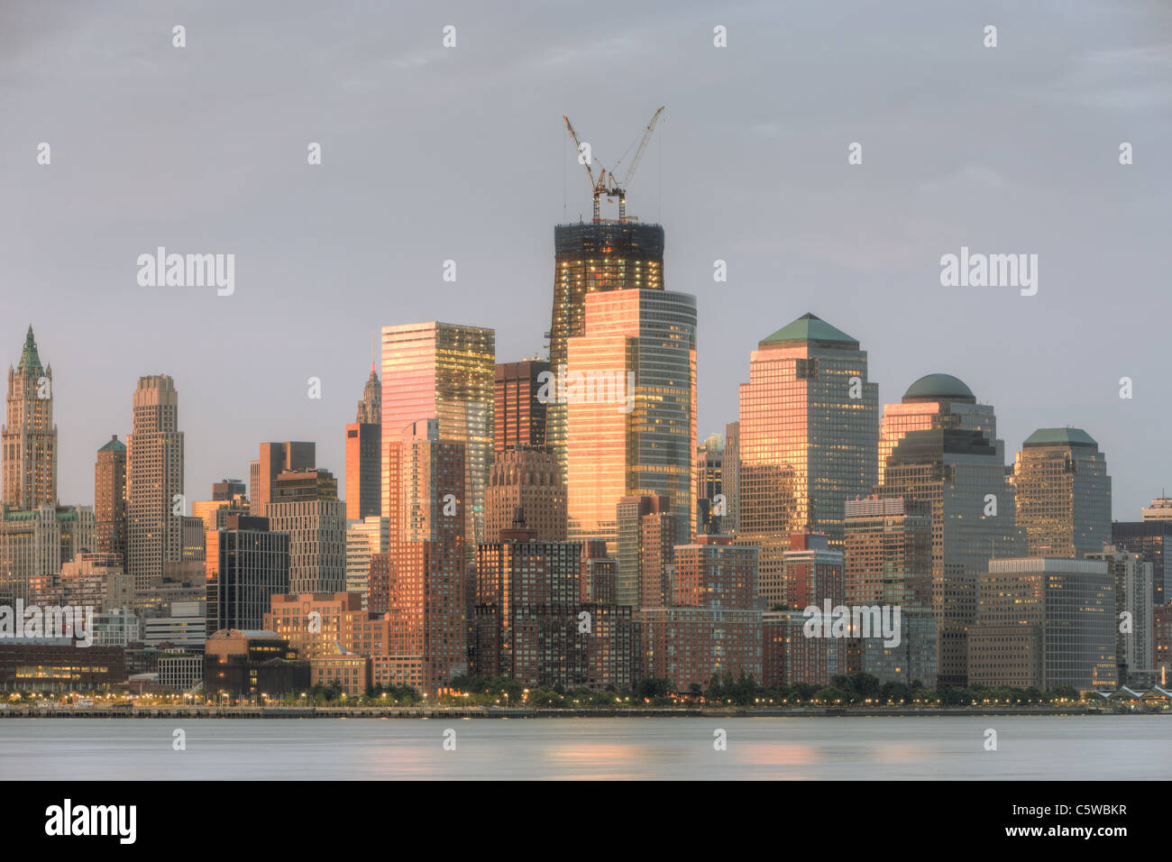 Il sunrise cielo colorato viene riflessa da edifici di Lower Manhattan, tra cui il World Financial Center e Battery Park City Foto Stock