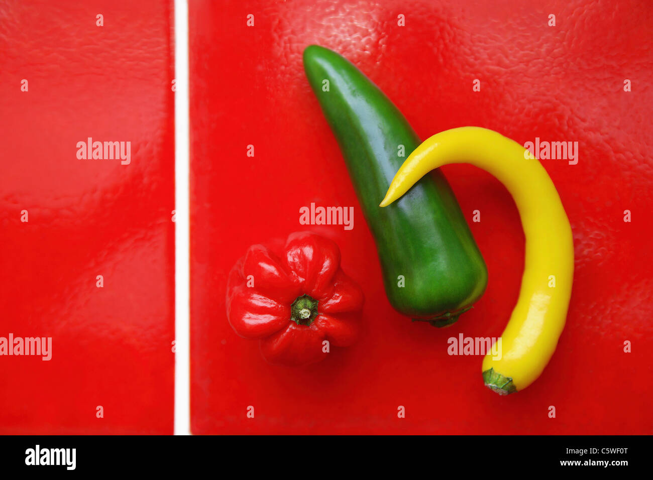 Il peperone e peperoncino baccello su tegole rosse, vista in elevazione Foto Stock