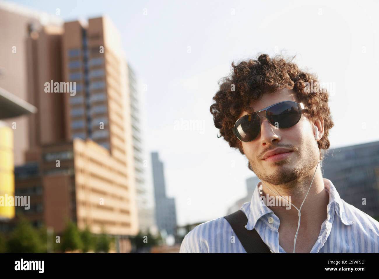 Germania Berlino, giovane uomo che indossa gli occhiali da sole, ritratto Foto Stock