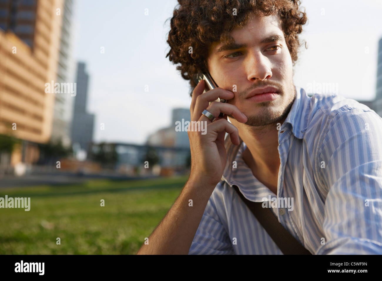 Germania, Berlino, giovane utilizzando il telefono cellulare e il ritratto Foto Stock