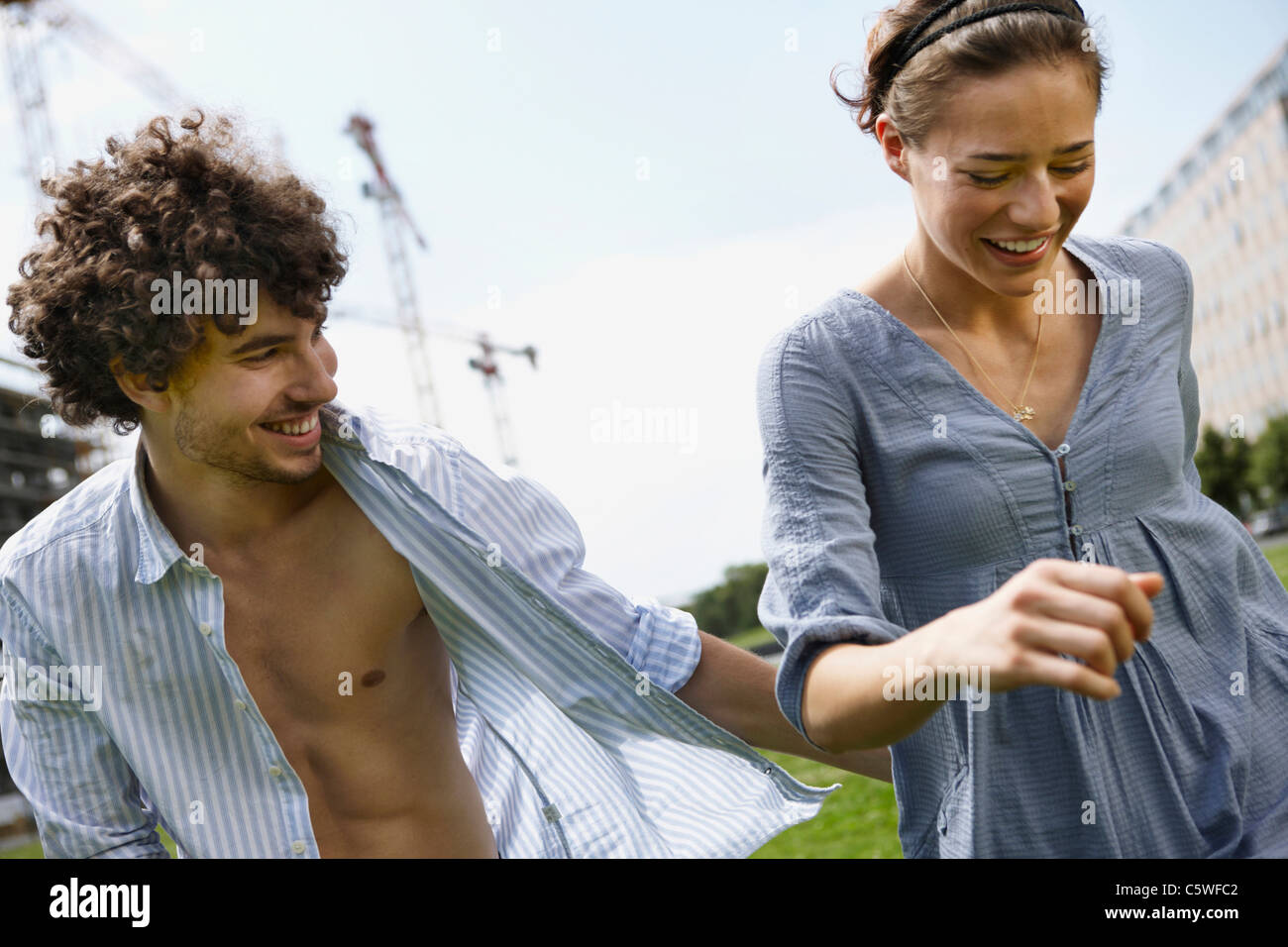 Germania, Berlino, coppia giovane Camminando fianco a fianco, ridendo, ritratto Foto Stock