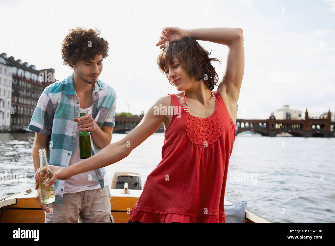 Germania, Berlino, giovane coppia in motoscafo, uomo guardando woman dancing, ritratto Foto Stock
