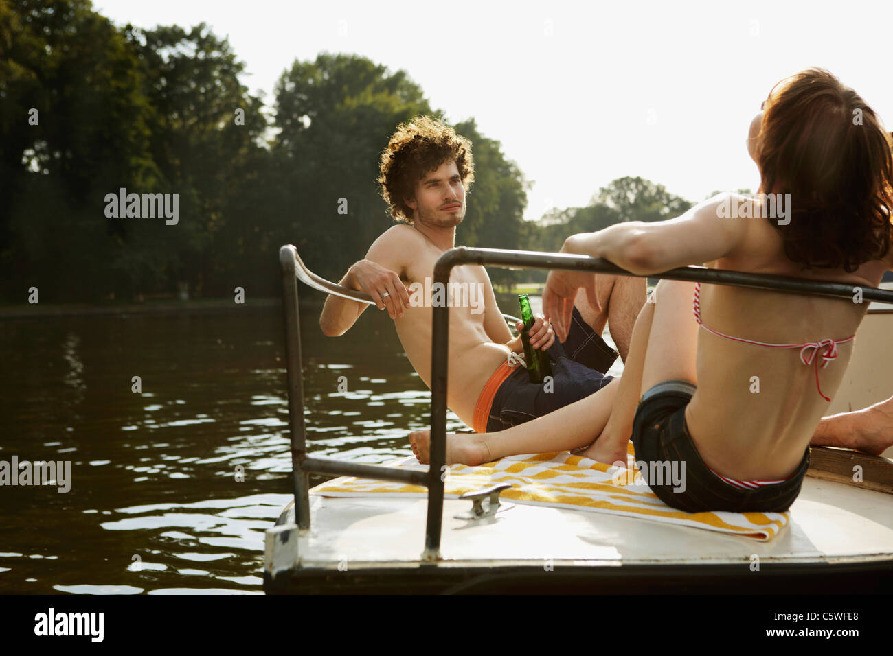 Germania Berlino giovane coppia su imbarcazione a motore, uomo del vaso di contenimento Foto Stock