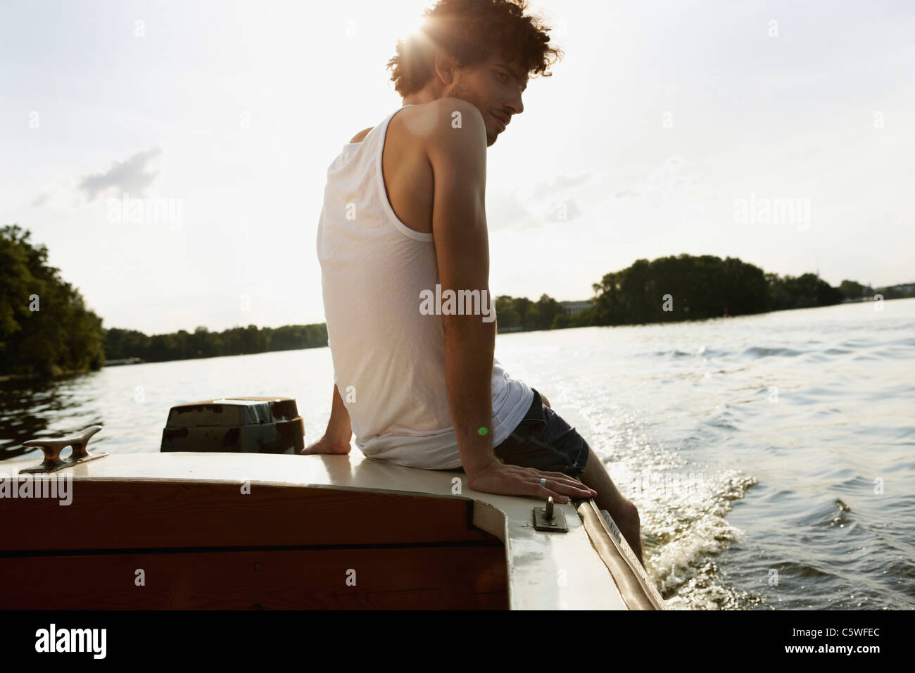 Germania Berlino, giovane uomo seduto su imbarcazione a motore Foto Stock