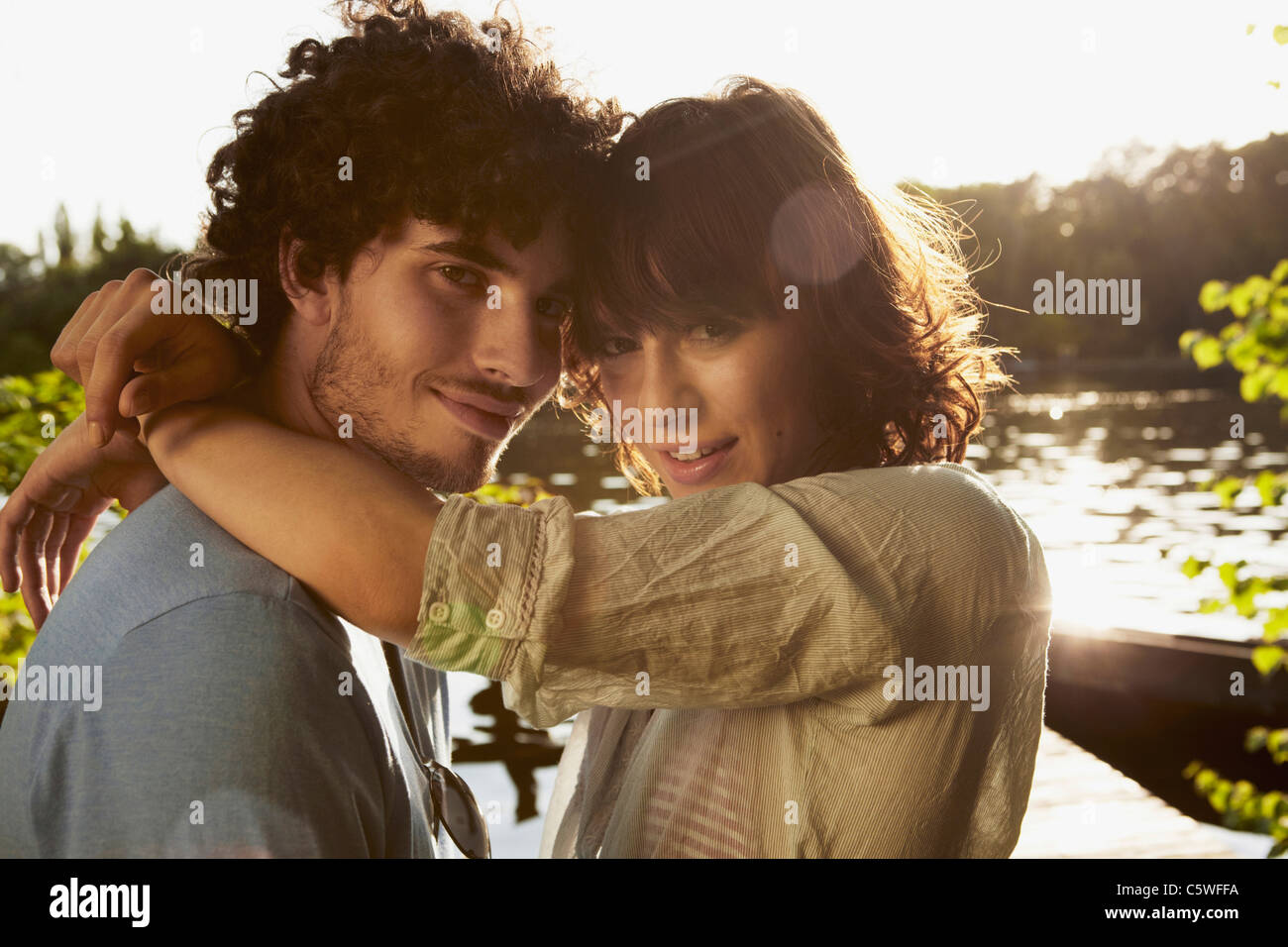 Germania Berlino giovane coppia abbracciando dal fiume Sprea, vista laterale, ritratto, close-up Foto Stock