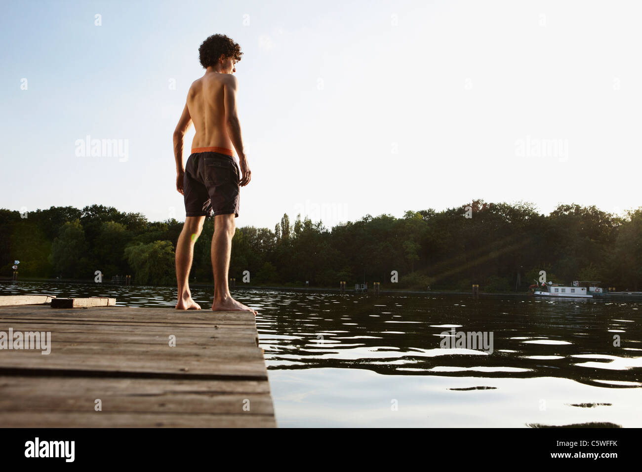 Germania, Berlino, fiume Spree, giovane uomo in piedi sul molo Foto Stock