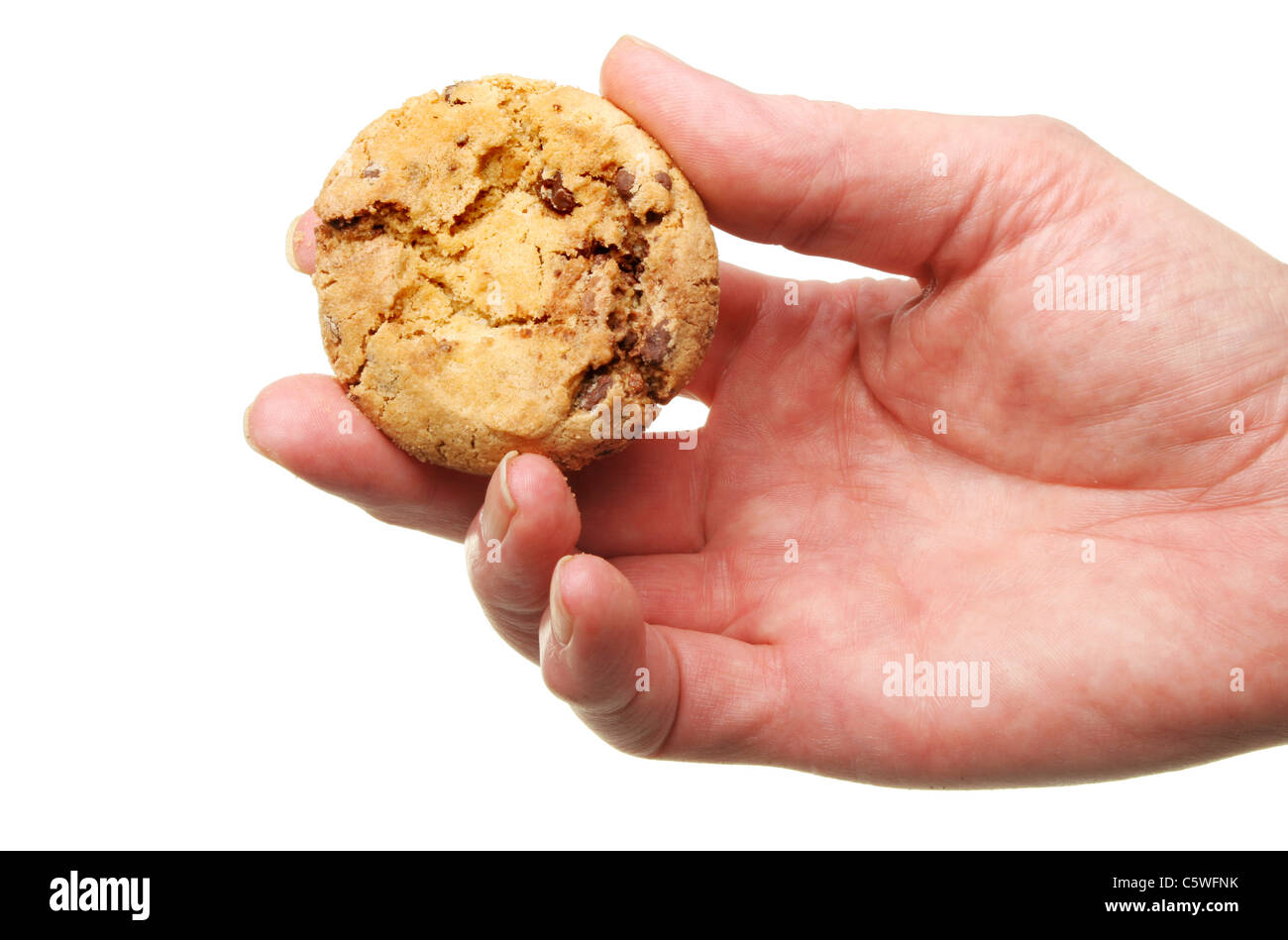 Primo piano di una mano che tiene un Chocolate Chip Cookie isolata contro bianco Foto Stock