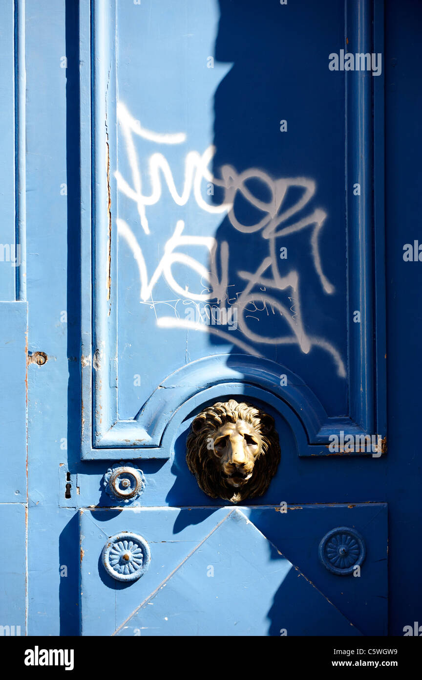 Porta blu e lion respingente deturpate da graffiti a Parigi. Foto Stock