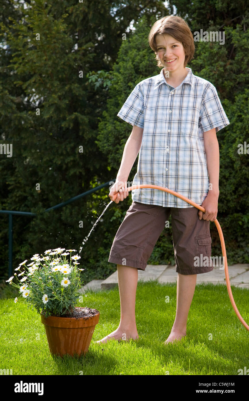 Germania, Baden-WÃ¼rttemberg, Stoccarda, ragazzo (12-13) impianto di irrigazione Foto Stock