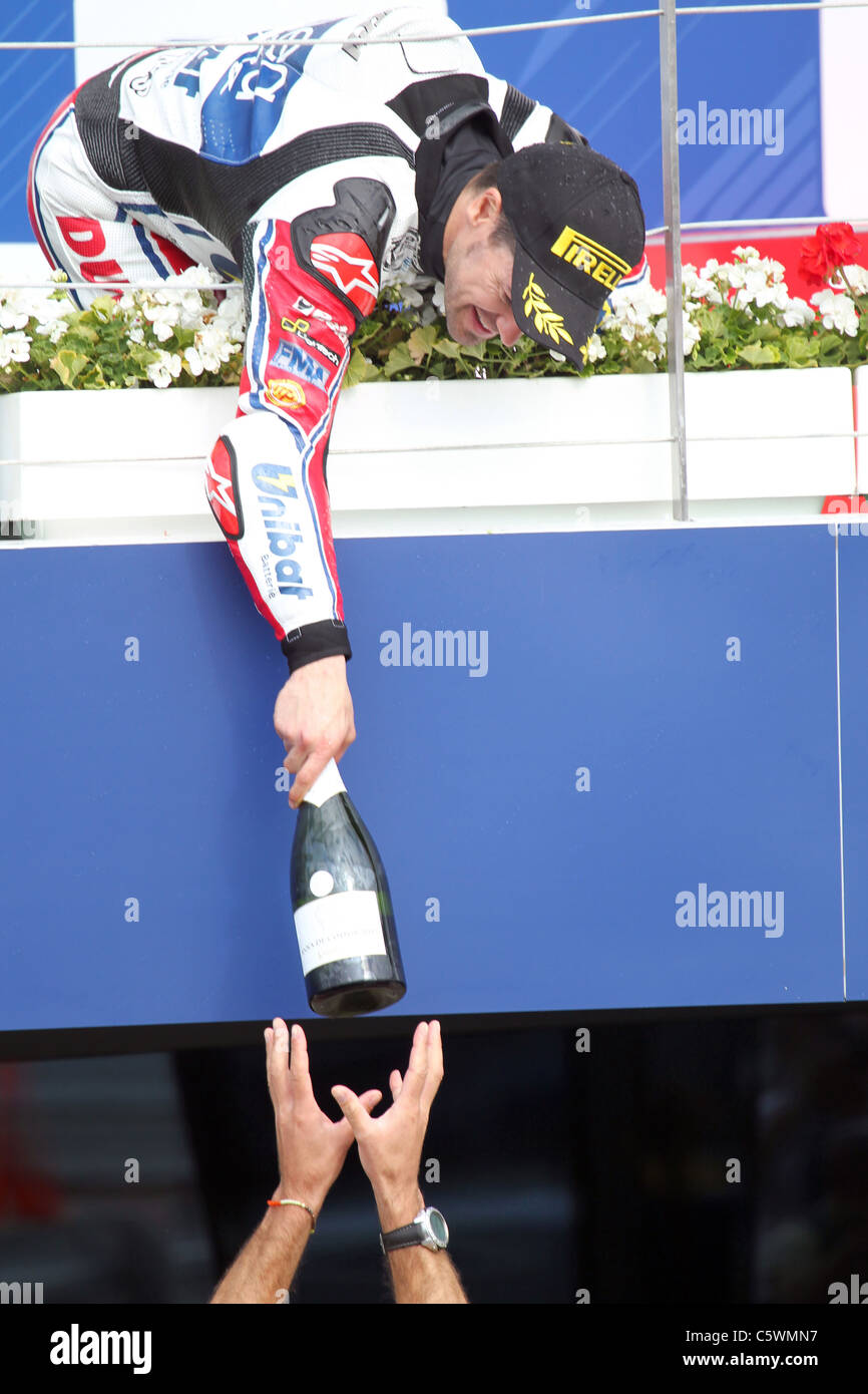 Vincitore della gara Carlos Checa passa il Champagne giù per il suo meccanico Foto Stock