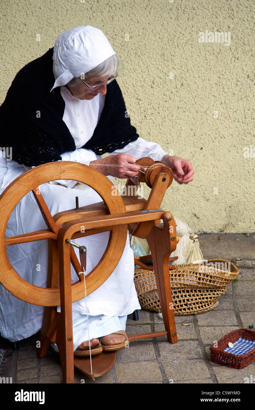 (Totnes Devon, Inghilterra) Tudor mercato organizzato ogni martedì in estate con le donne in costume servendosi di una tradizionale ruota di filatura. Foto Stock