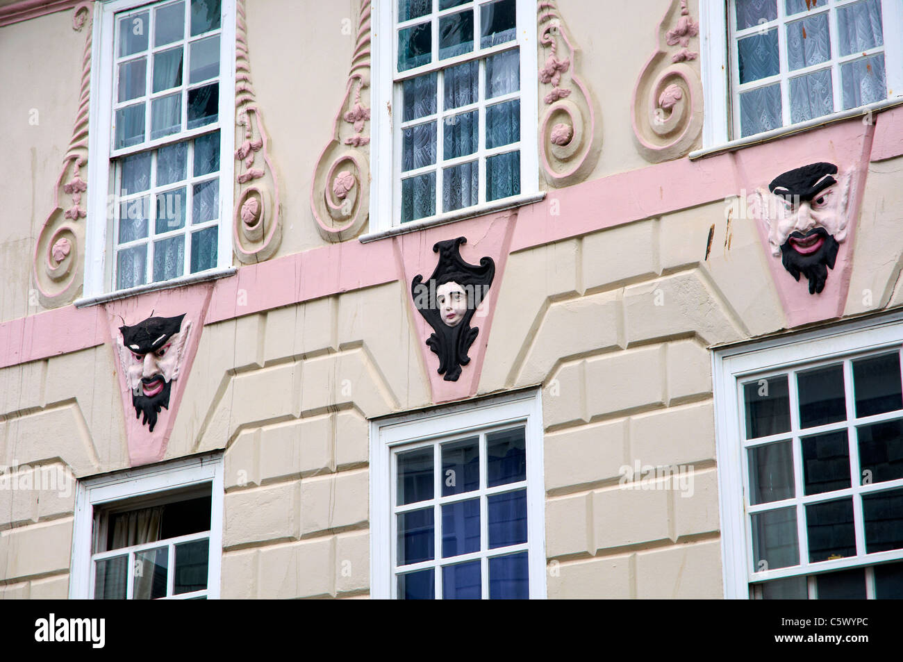 Edificio georgiano a Totnes, Devon, Inghilterra con elaborati e decorazione dipinta maschera teatrale facce di stile. Foto Stock