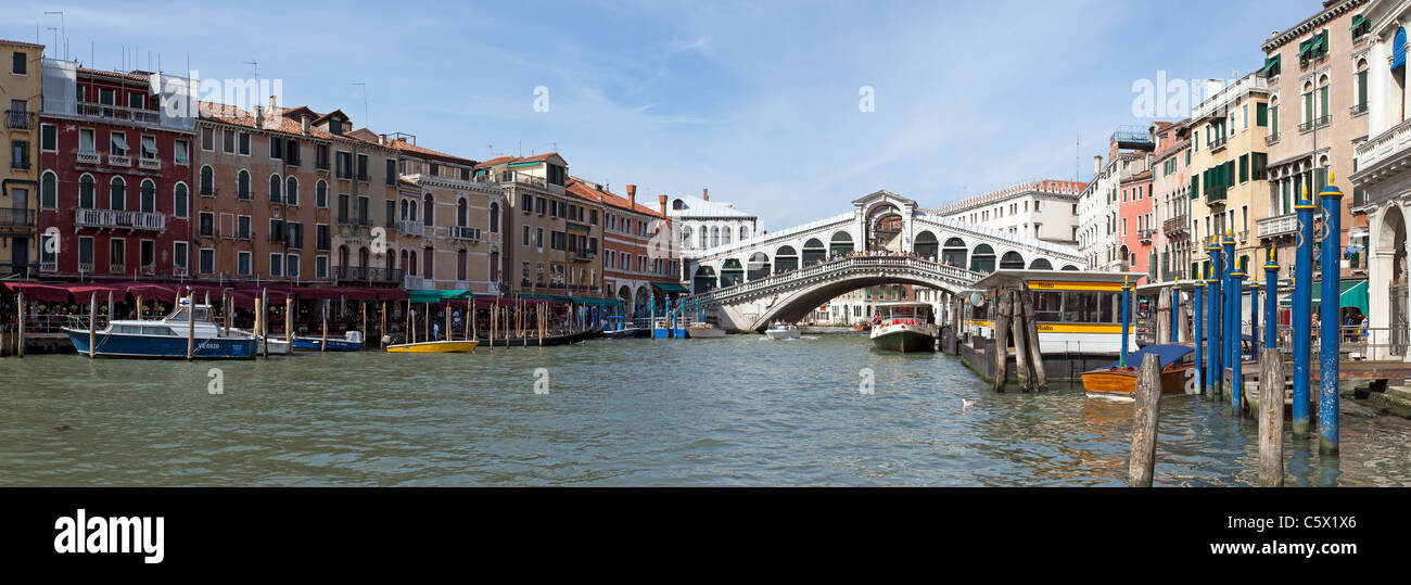 Ponte di Rialto sul Canal Grande di Venezia, Italia. Ampio angolo immagine Mostra gli hotels di rivestimento del canale e vaporetti in viaggio Foto Stock