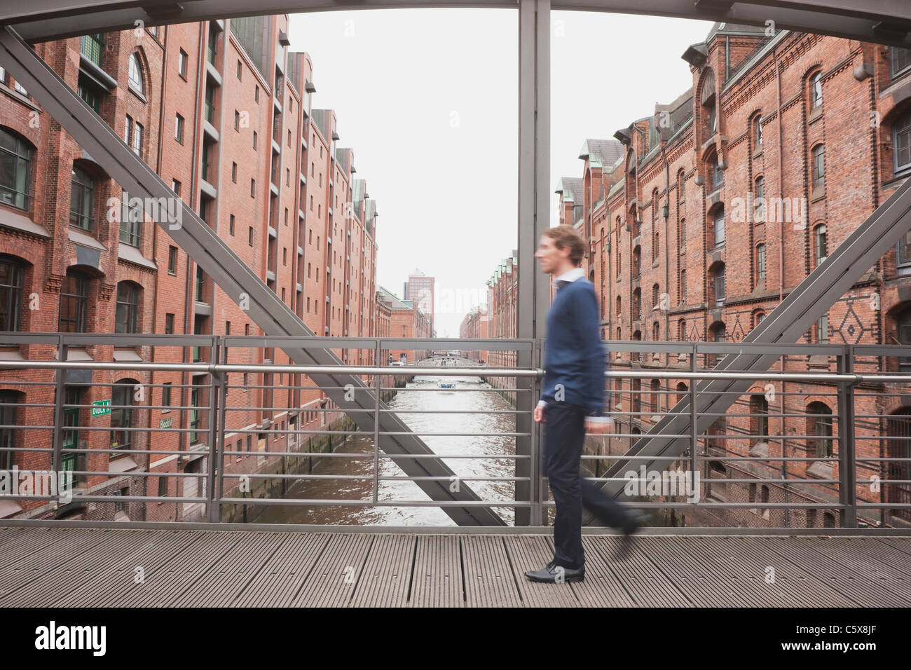 Germania, Amburgo, imprenditore attraversando il ponte, vista laterale Foto Stock