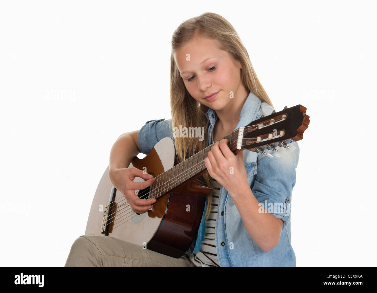 Ragazza a suonare la chitarra contro uno sfondo bianco Foto Stock