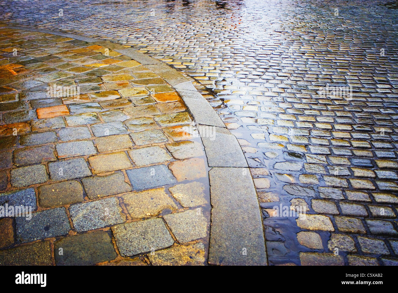 Cobblestone pavement intrisa di pioggia Foto Stock