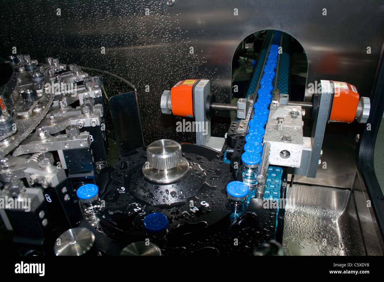 Una parte di una macchina il lavaggio di bottiglie in fabbrica per la produzione di medicinali Foto Stock