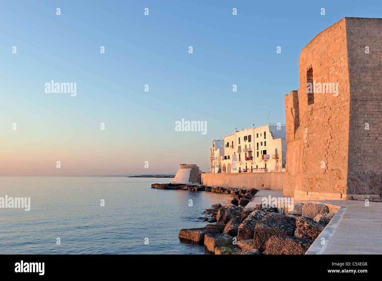 Il vecchio castello e mura del porto all'alba nella vecchia città di Monopoli, Italia Foto Stock