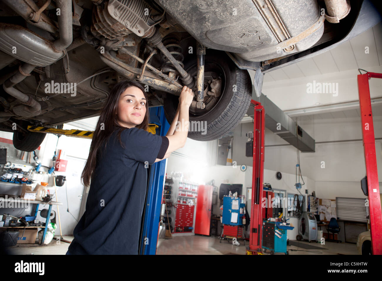 Ritratto di una donna meccanico che lavora sul lato inferiore di un  automobile Foto stock - Alamy