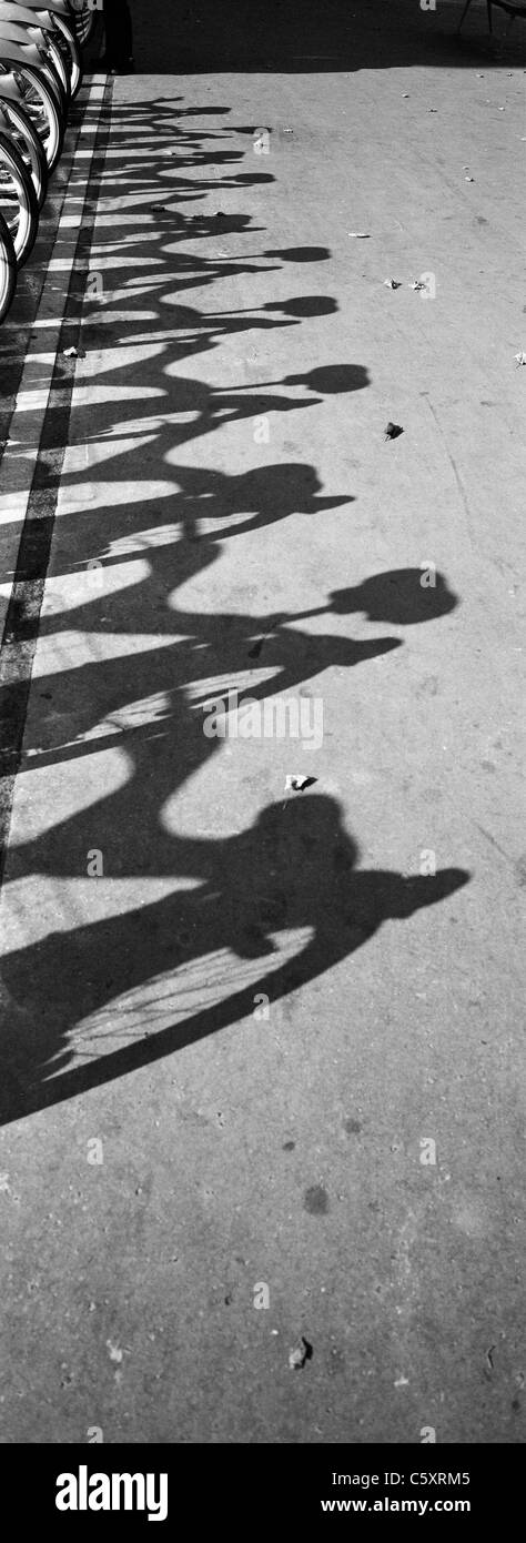 Una scena di strada di Parigi in Francia che mostra le ombre di Velib bike, una scala grande pubblico sistema bike in Parigi Francia. Foto Stock