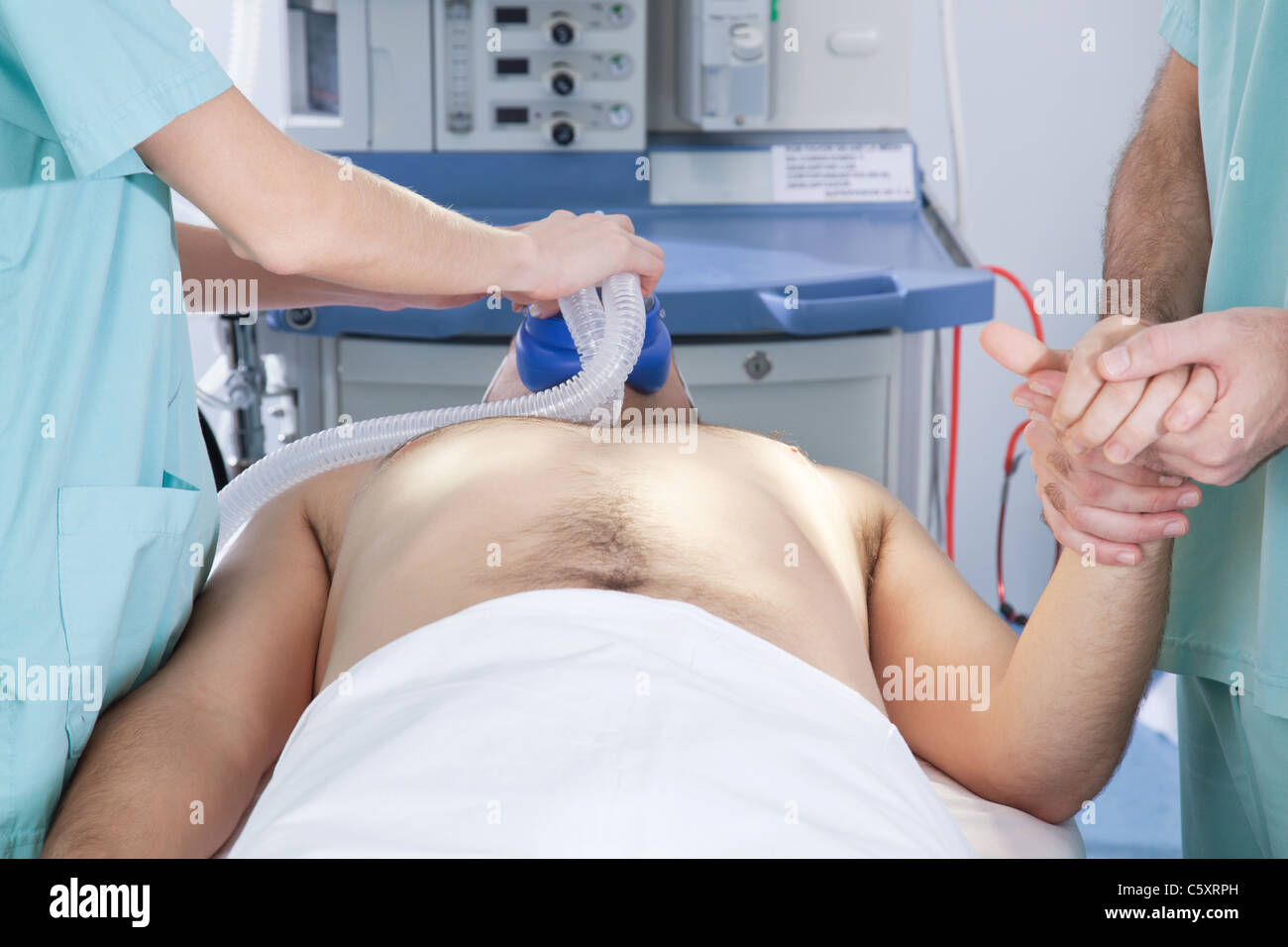 Un anestesista la preparazione di un paziente per la chirurgia Foto Stock