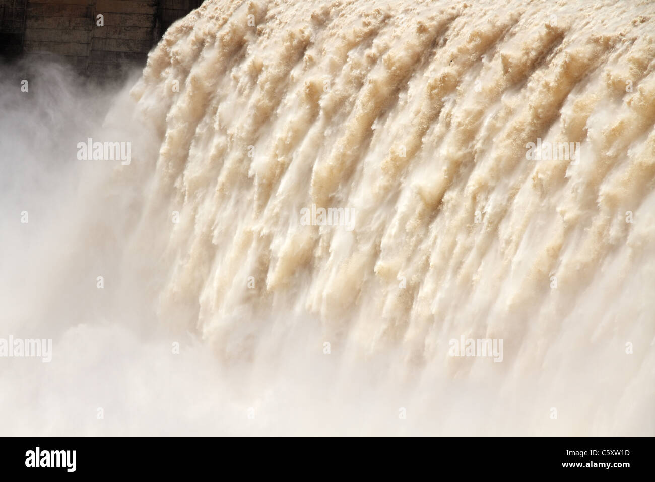 Forte dell'acqua che scorre con uno spruzzo di acqua dall'apertura paratoie di una diga di grandi dimensioni Foto Stock