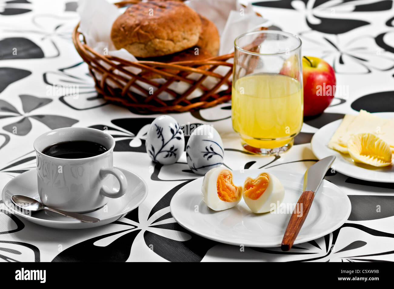 La prima colazione con il cuore a forma di uovo, caffè, succo di arancia, pane, burro e formaggio e un apple Foto Stock