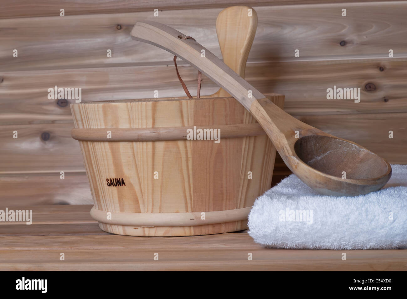 Benna con siviera sulla parte superiore del telo in un legno sauna Foto Stock