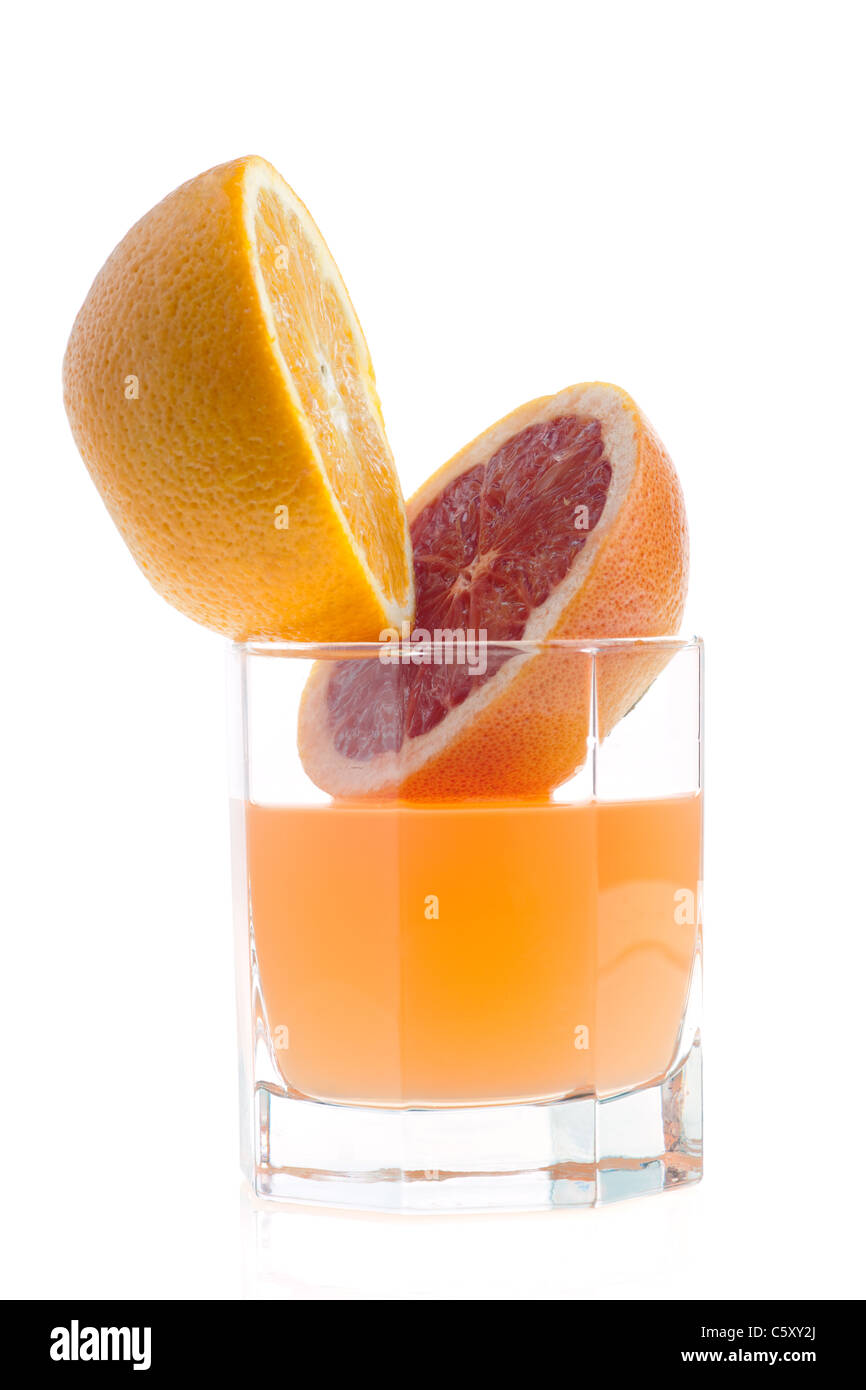 Due metà di pompelmo e succo di frutta in vetro su bianco Foto Stock
