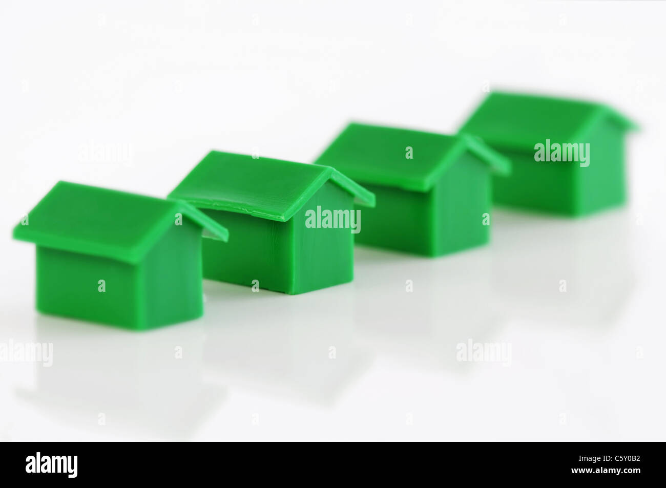 Quattro modello verde case in una riga Foto Stock