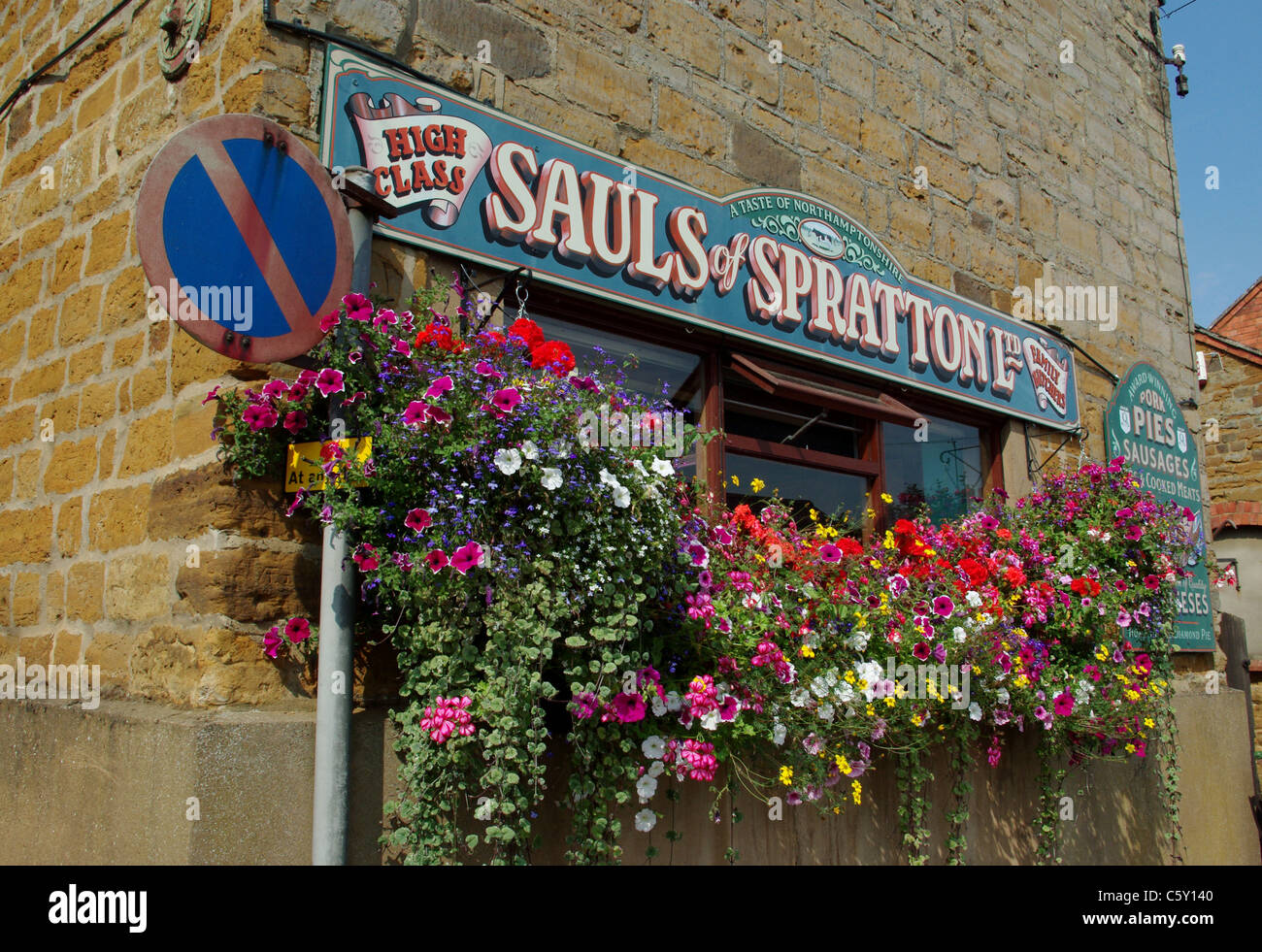 I fiori decorano le finestre di Saul's, un macellaio locale ben noto nel villaggio di Spratton, Northamptonshire, Regno Unito Foto Stock