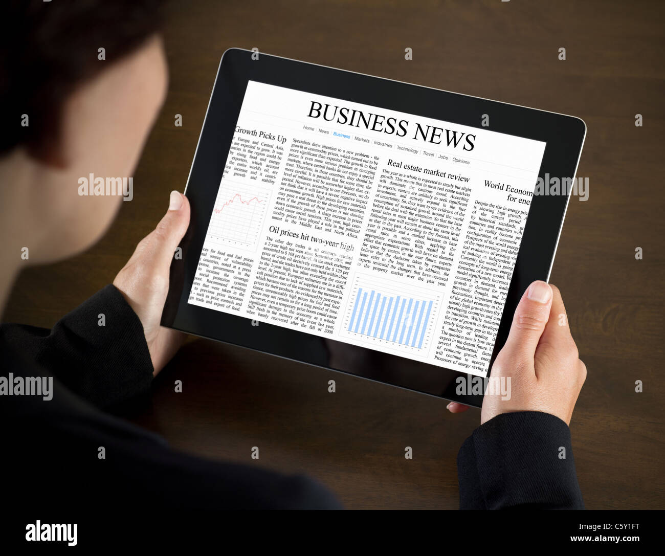 Business donna la lettura di notizie aziendali sul dispositivo touchscreen. Foto Stock