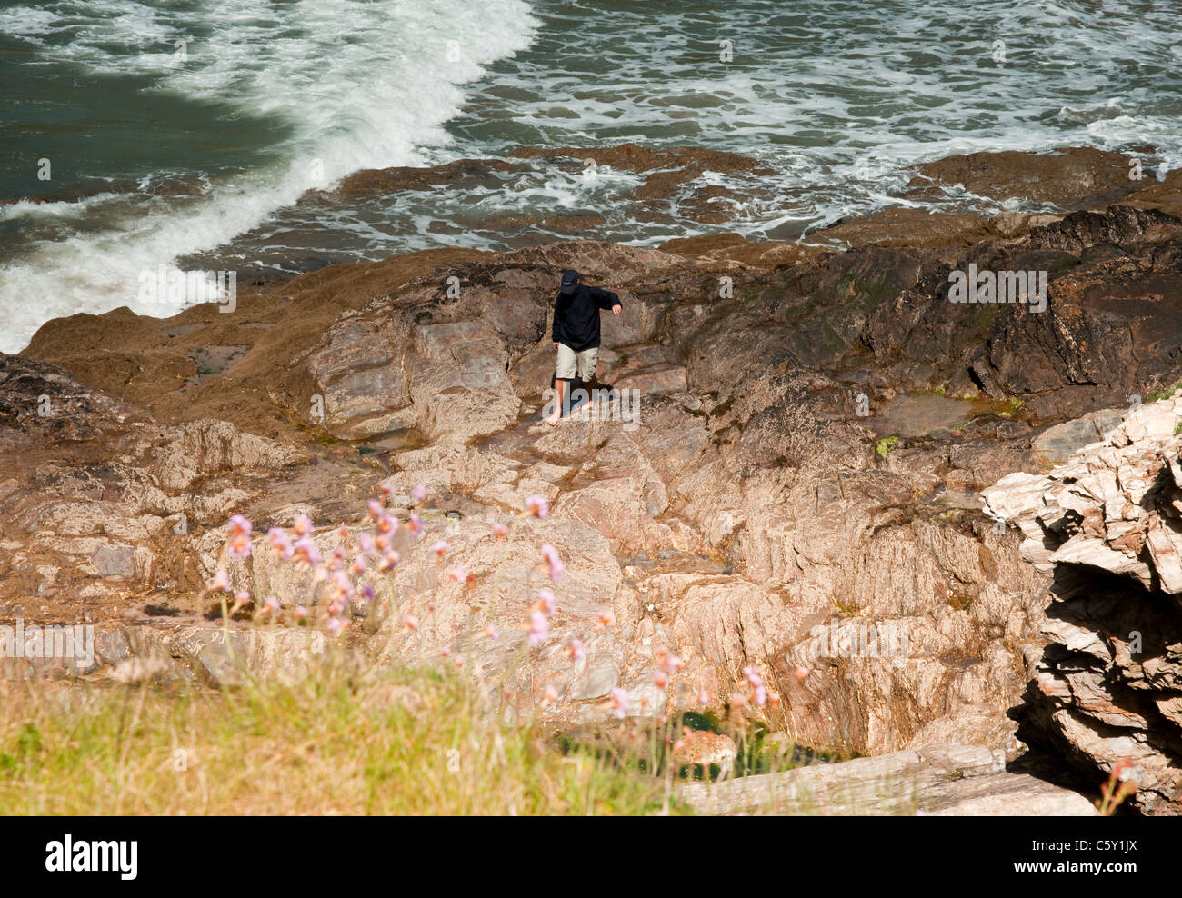 Un paesaggio colpo di qualcuno a piedi tra le piscine di roccia a Bovisand Bay, Devon Foto Stock