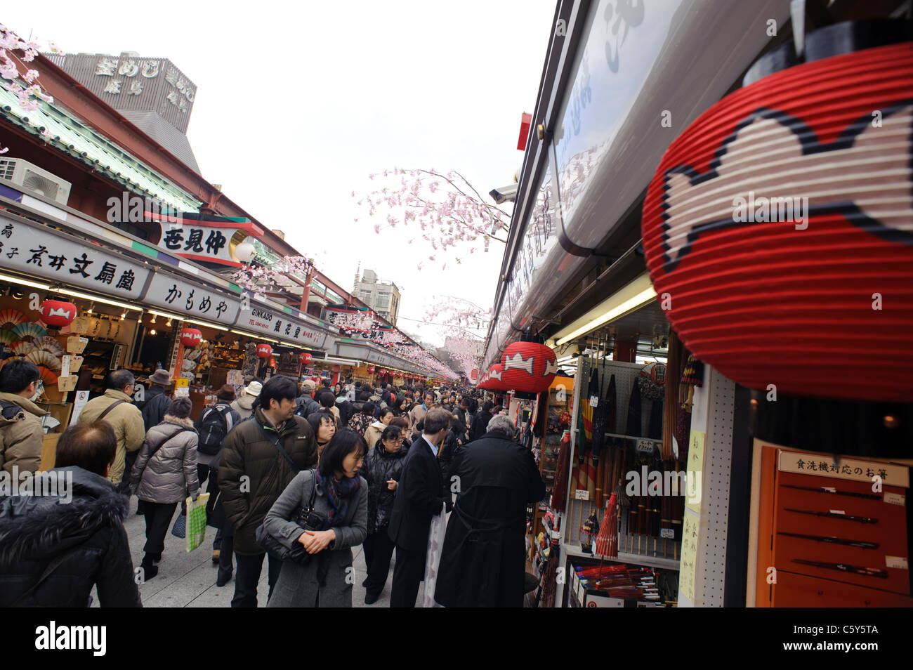 La folla di persone a piedi attraverso negozi nel porticato che conduce fino al tempio di Sensoji, Asakusa, Tokyo, Giappone Foto Stock