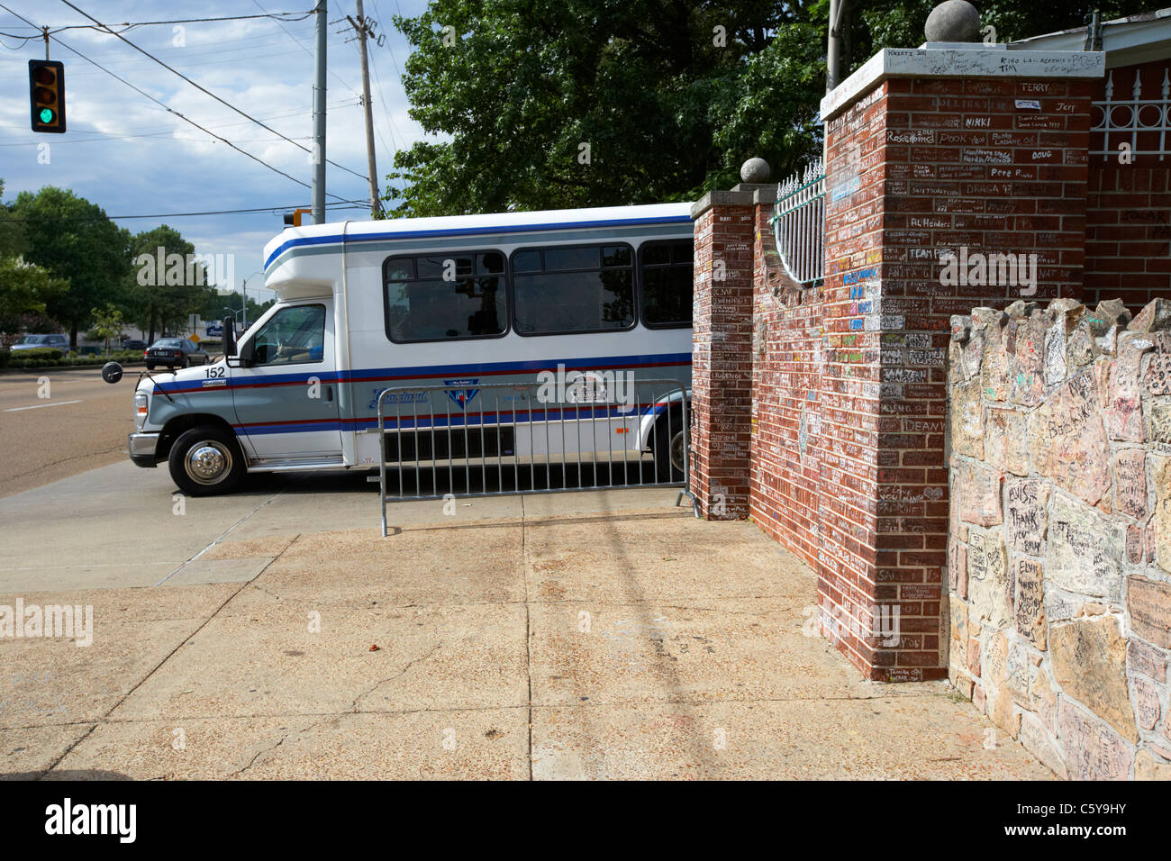 Tour bus lasciando i cancelli di graceland oltre il muro basso coperto di graffiti al di fuori di Graceland Memphis, Tennessee, Stati Uniti d'America Foto Stock