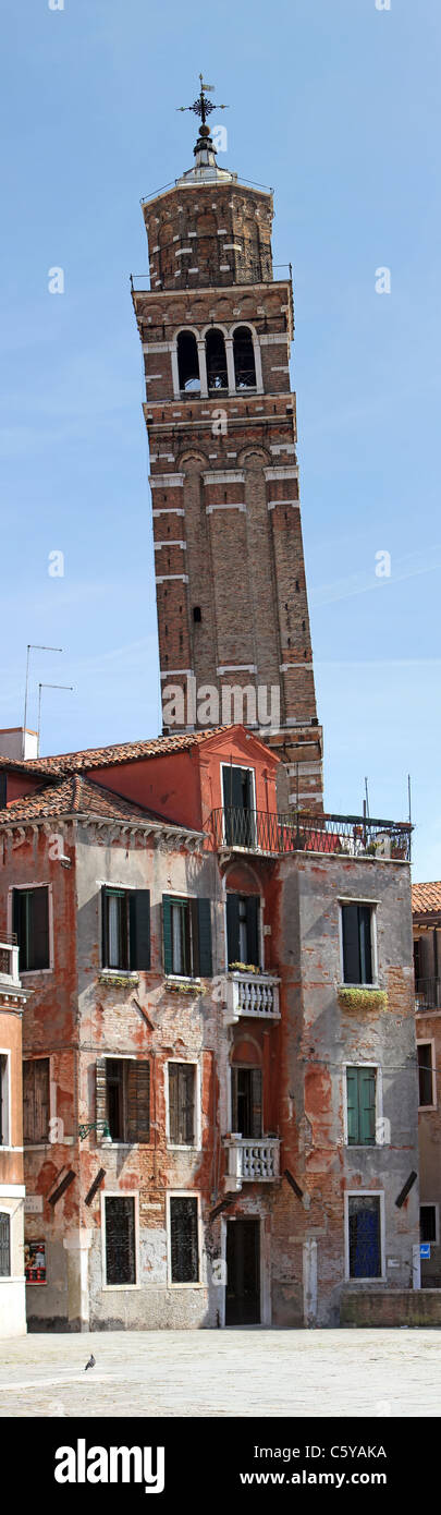 Uno dei molti pendente torri della chiesa a Venezia, Italia con antico edificio di fronte mostra di architettura. Foto Stock