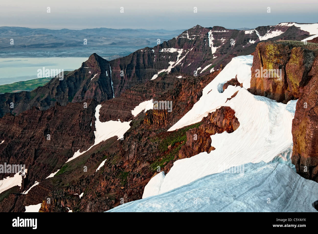 La prima luce bagna il bordo orientale e resti di nevicate invernali sulla cima dell'Oregon Steens Mountain Wilderness Area. Foto Stock