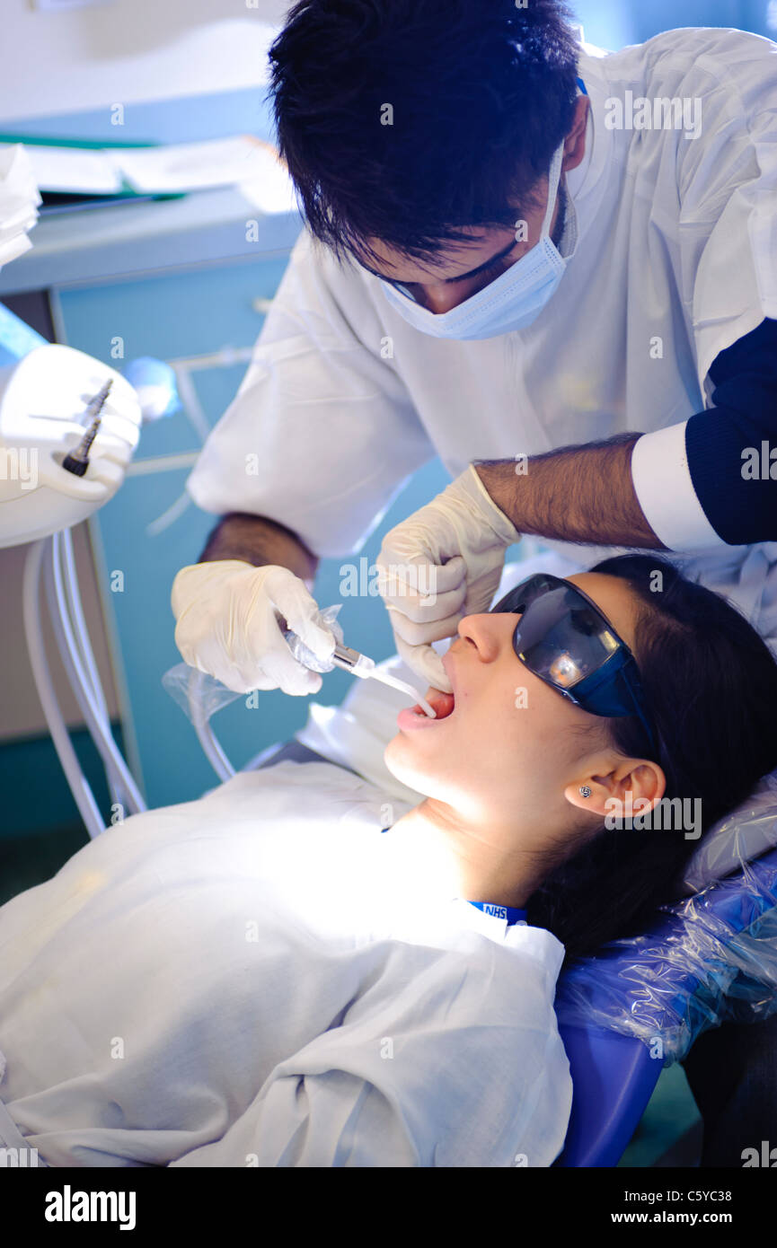 Odontoiatria maschio studente di eseguire un intervento di chirurgia dentale in odontoiatria femmina studente in odontoiatria clinica Foto Stock