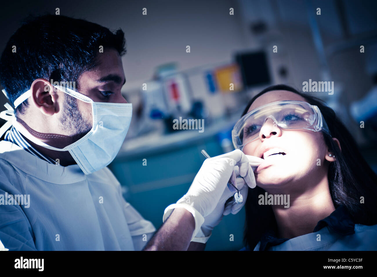 Odontoiatria maschio studente di eseguire un intervento di chirurgia dentale in odontoiatria femmina studente in odontoiatria clinica Foto Stock