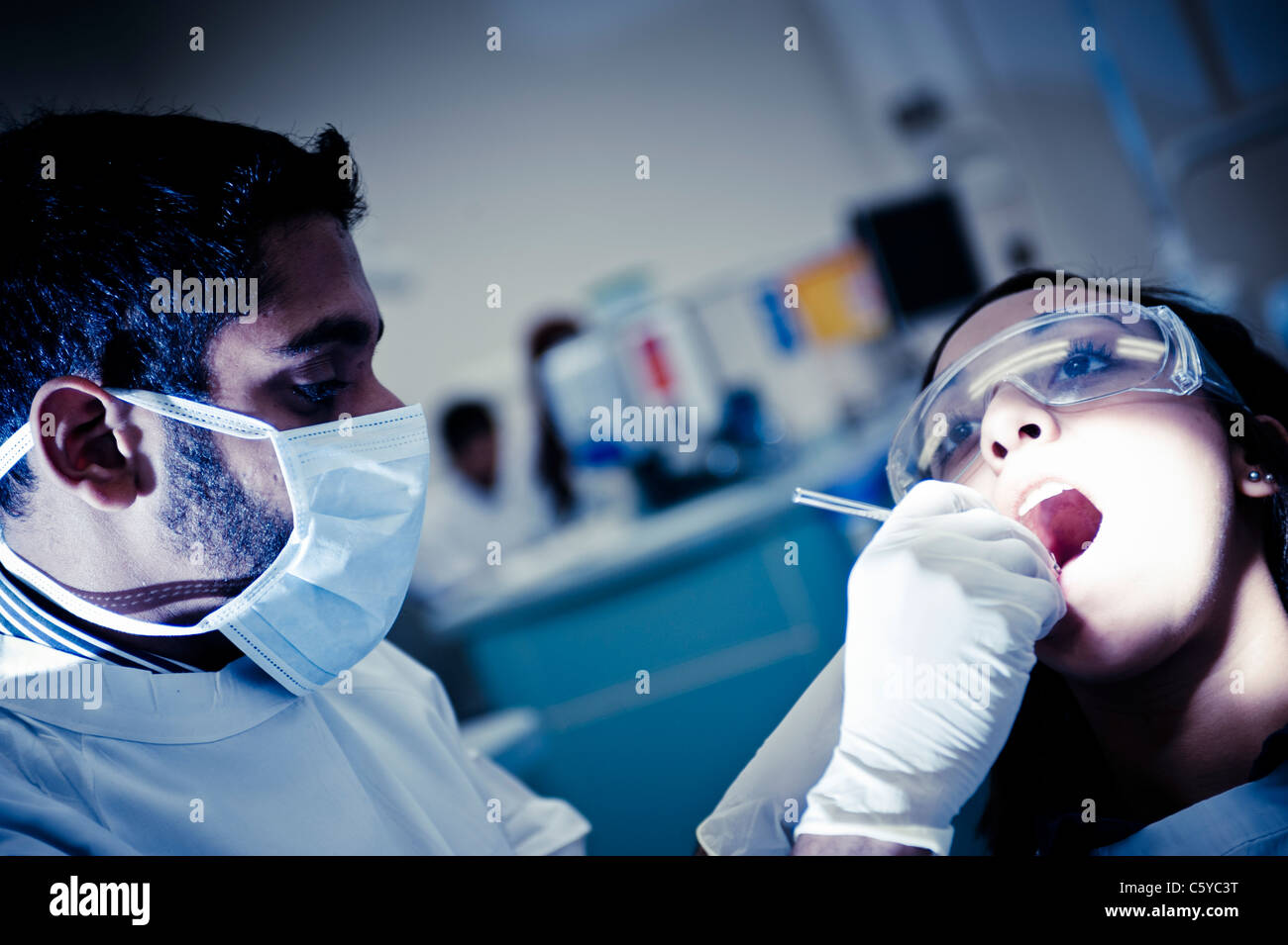 Odontoiatria maschio studente di eseguire un intervento di chirurgia dentale in odontoiatria femmina studente in odontoiatria clinica Foto Stock