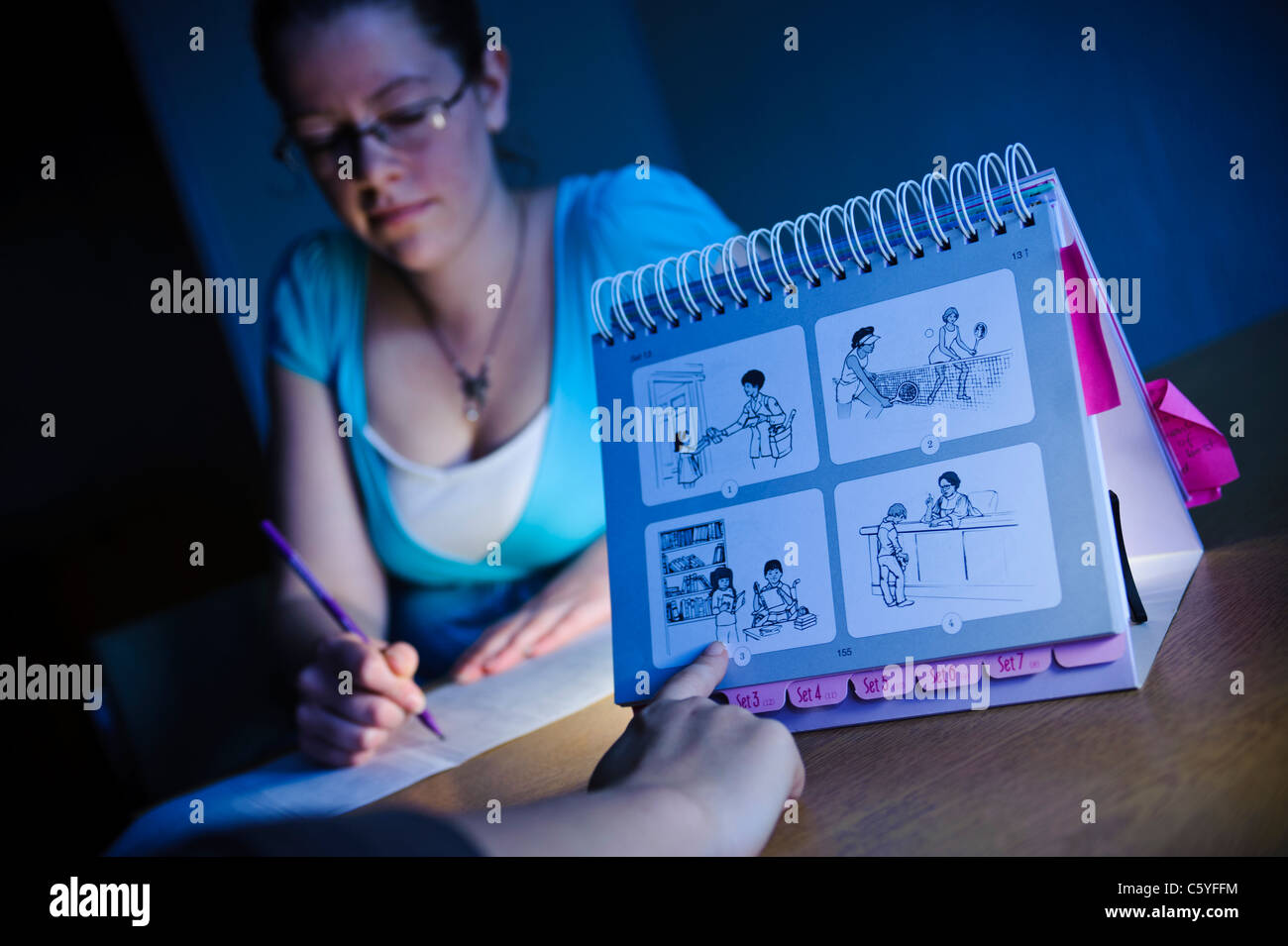 Parlato femminile e la lingua terapista nella sessione di formazione con picture card blu Foto Stock