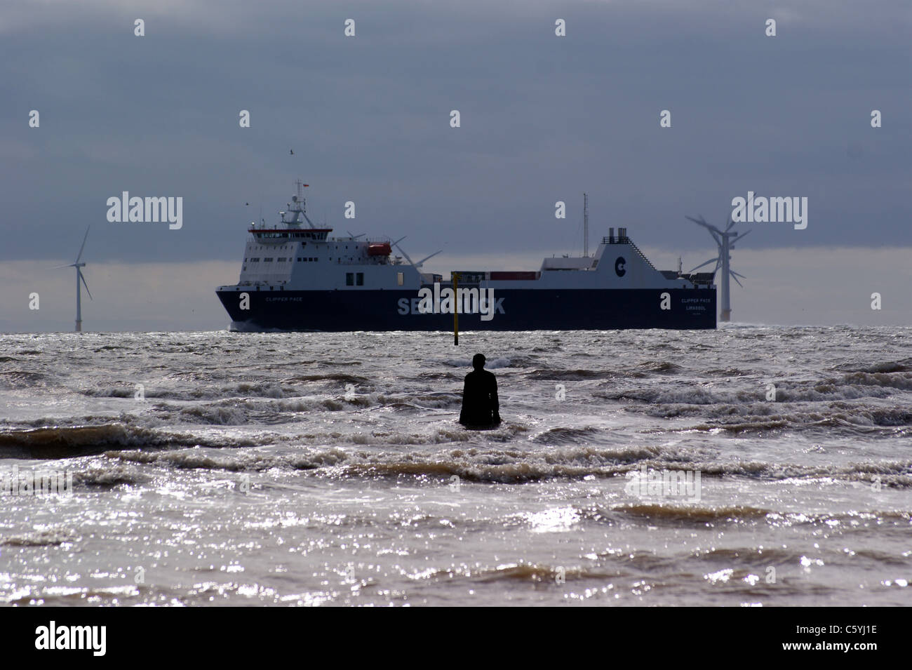 "Un altro luogo", Antony Gormley's statue in Crosby beach, Liverpool, Merseyside England, Liverpool wind farm, contenitore di nave Foto Stock