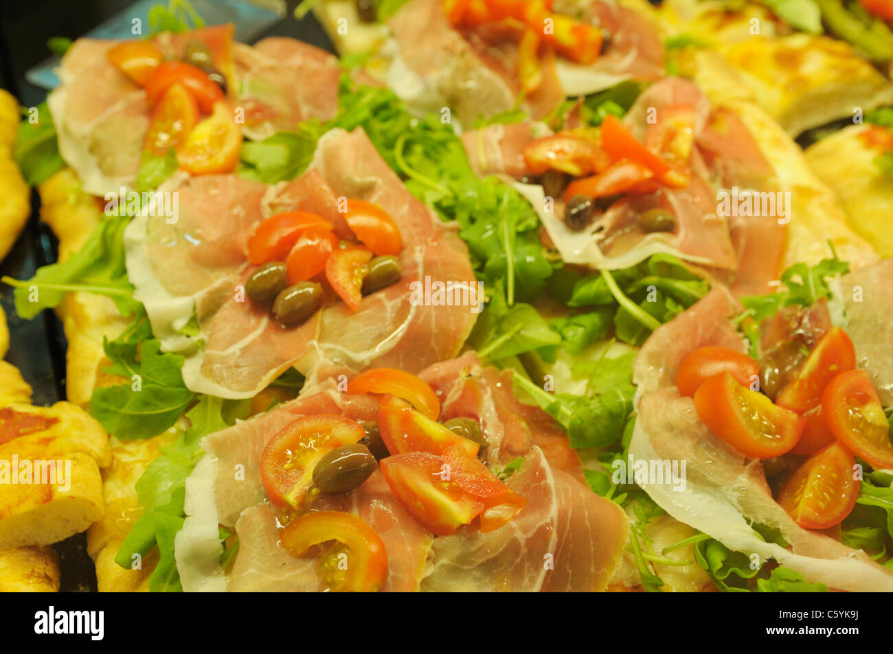 Pizza con le olive, il prosciutto e i pomodori, Campania, Italia Foto Stock
