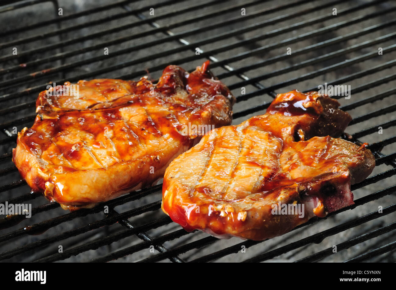 Due barbecue costolette di maiale la finitura sul grill Foto Stock