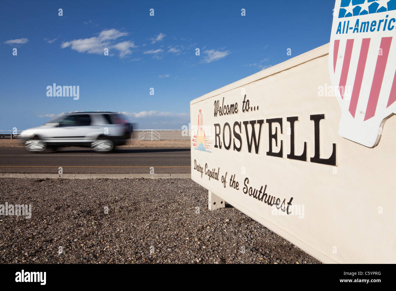 Stati Uniti d'America, Nuovo Messico, Roswell, Auto velocizzando il passato insegna di benvenuto Foto Stock
