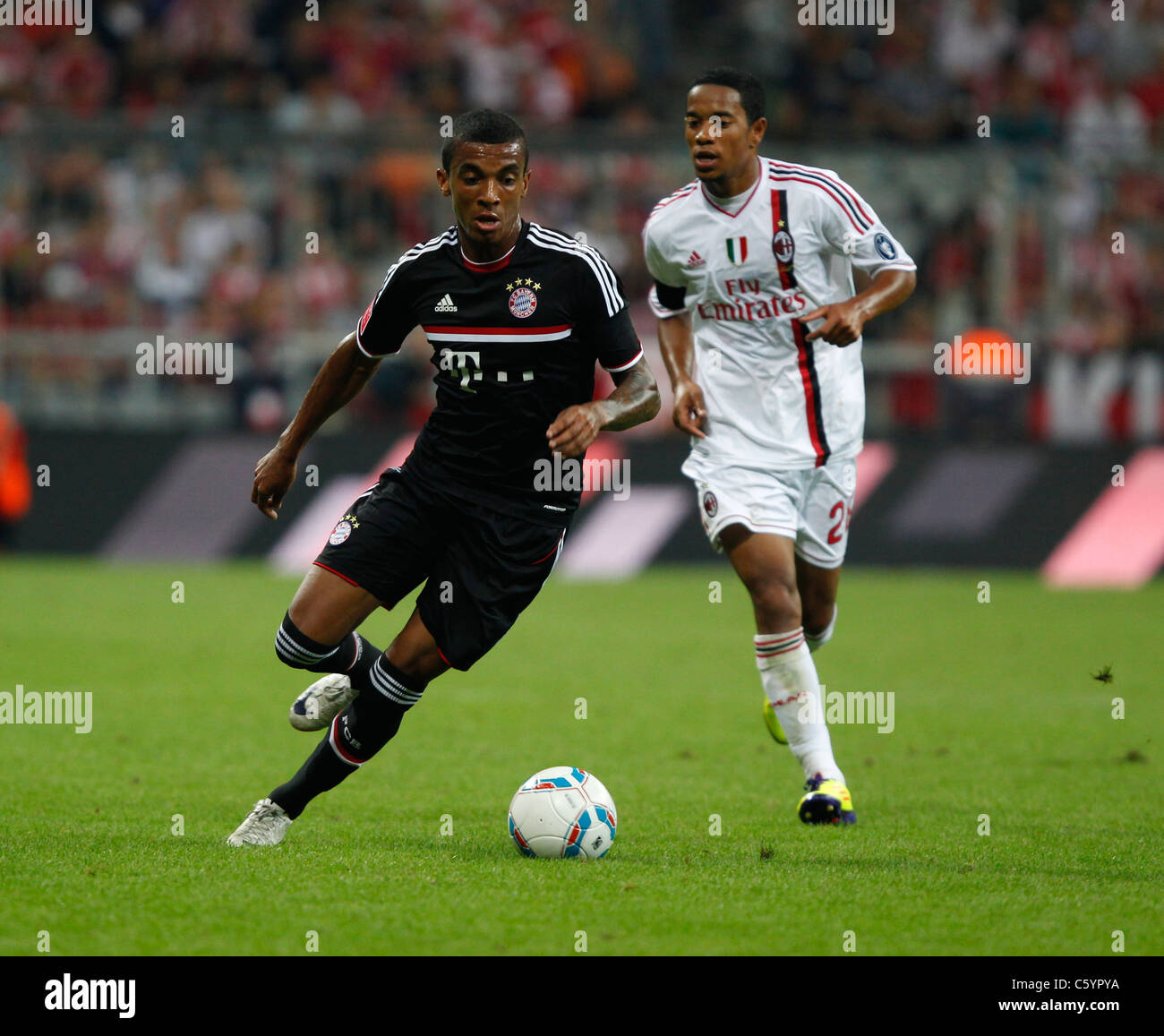 FC Bayern Monaco giocatore Luiz Gustavo con la sfera e Urby Emanuelson di AC Milano Foto Stock