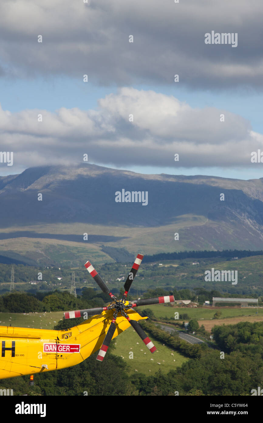 RAF Sea King Salvataggio in elicottero a Ysbyty Gwynedd, con Snowdonia in background Foto Stock