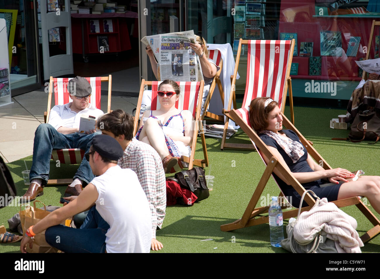Persone su sedie a sdraio fuori Foyles presso la Royal Festival Hall Foto Stock